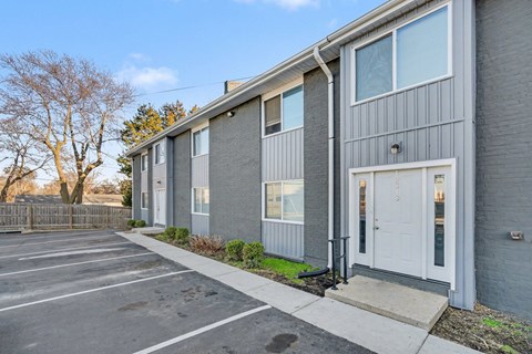 A grey building with a white door and windows.