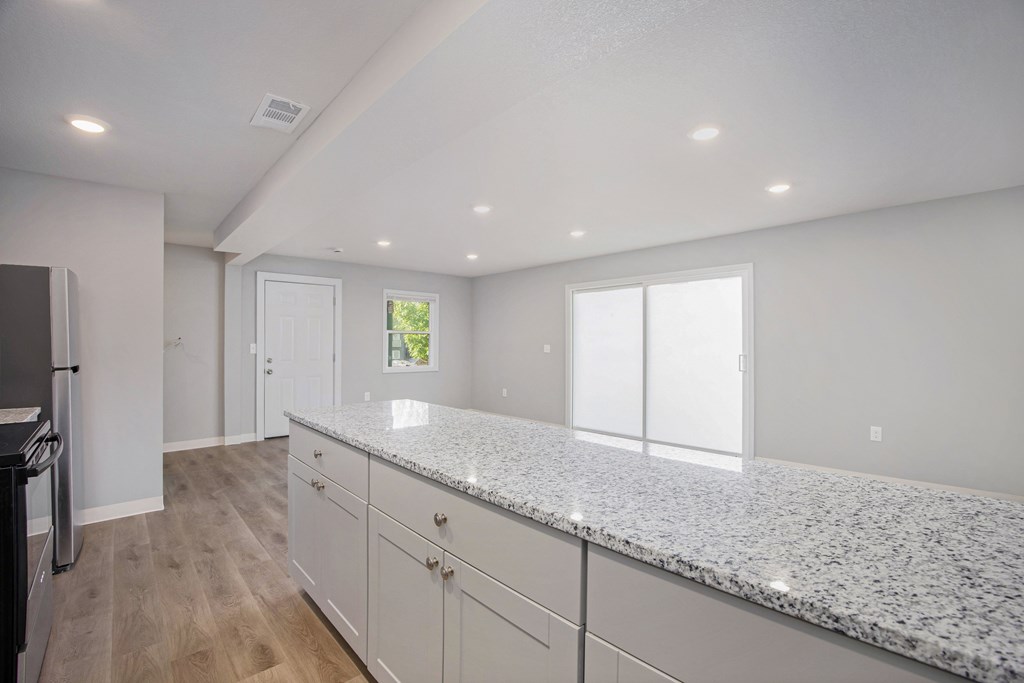 A kitchen with granite countertops and white cabinets.at Palisades Apartments, Kansas City, 64133