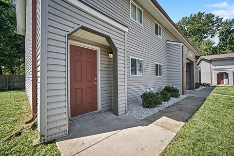 A house with a red door and a grey siding.