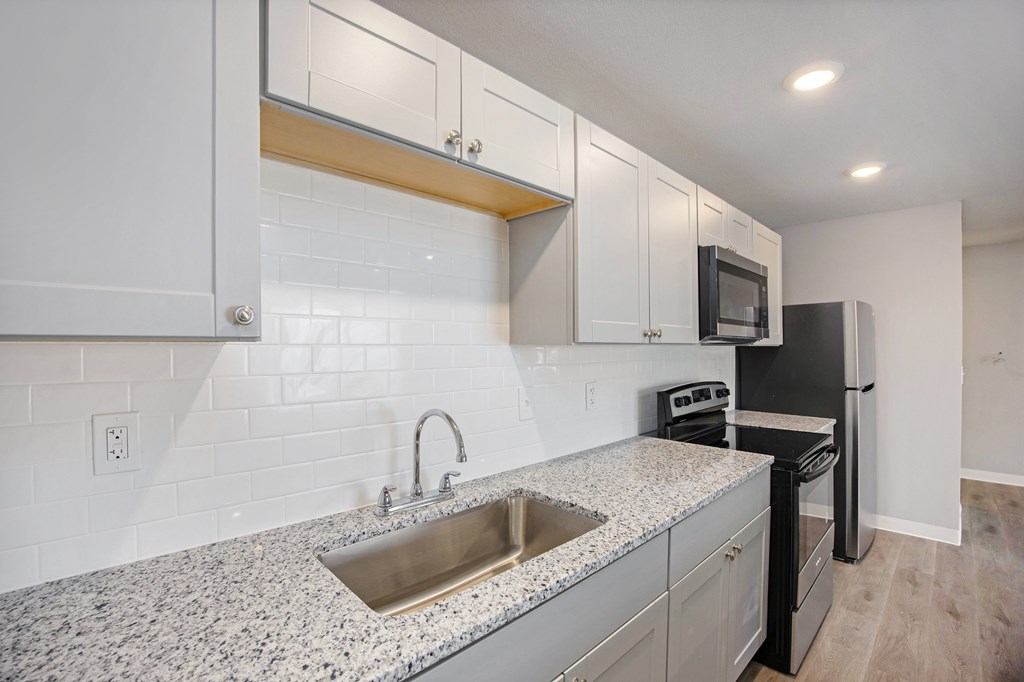 A kitchen with a sink, microwave, and oven.at Palisades Apartments, Kansas City, MO