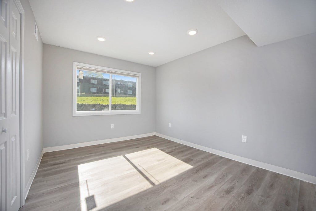 A room with a large window and a wooden floor.at Palisades Apartments, Kansas City Missouri