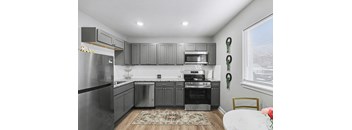 A modern kitchen with stainless steel appliances and grey cabinets.