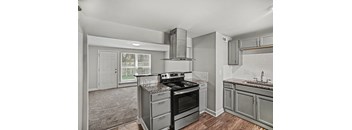 A modern kitchen with a black stove top oven and a white counter top.