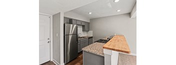 A kitchen with a stainless steel refrigerator and a wooden cutting board.