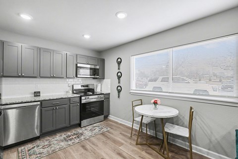 A kitchen with a table and chairs by the window.