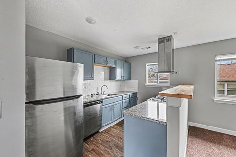 A kitchen with a stainless steel refrigerator and blue cabinets.