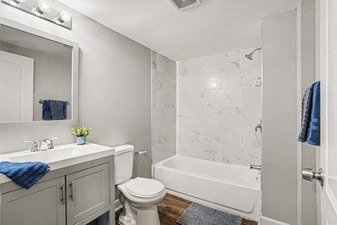 A white bathroom with a toilet, sink, and bathtub.