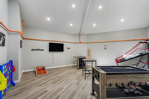 A room with a pool table, a basketball hoop, and a foosball table at Mayfair Apartments, Kansas City, Missouri
