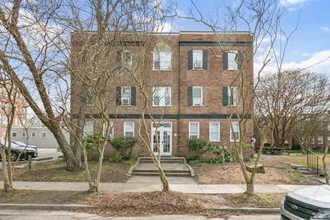 A red brick building with a white door and windows.