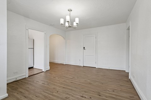 A room with a chandelier and wooden floors. at Shipyard Shores Apartments, Newport News, Virginia