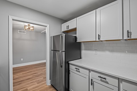 A kitchen with a black fridge and white cabinets. at Serenity Place Central, Tallahassee, Florida
