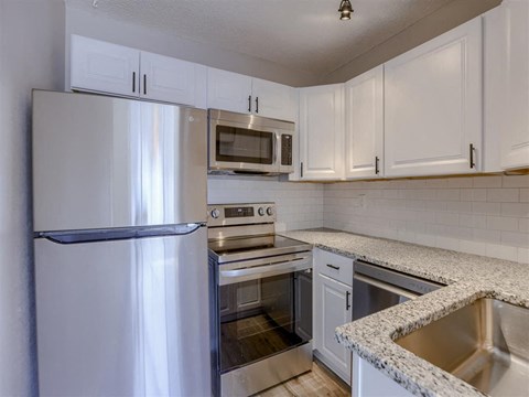 a kitchen with stainless steel appliances and white cabinets
