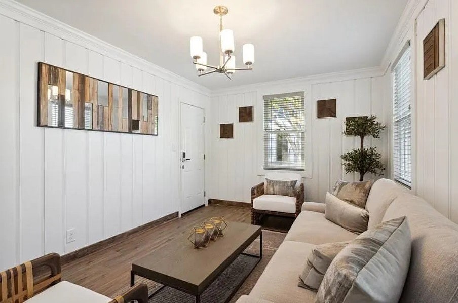 A living room with a white couch and a wooden coffee table.