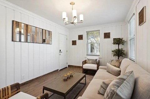 A living room with a white couch and a wooden coffee table.