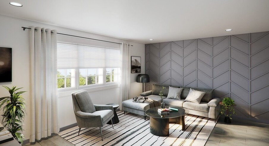 A modern living room with a grey sofa, a grey armchair, a coffee table, and a plant.