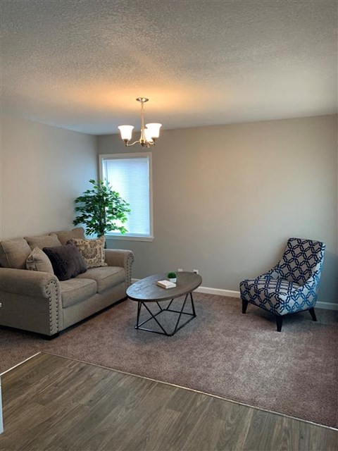a living room with a couch and a chair and a table