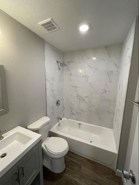 a bathroom with a toilet and a tub and a sink