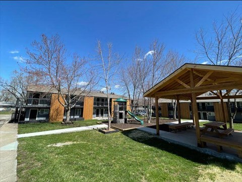 a playground with a pavilion in front of a building