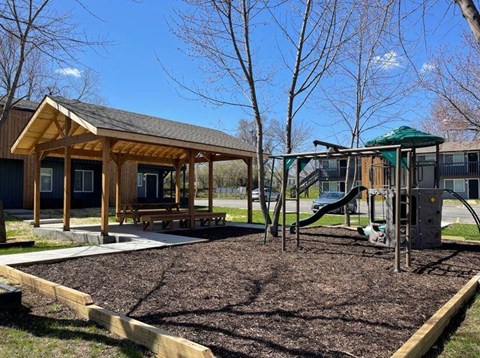 a playground with a swing set and a pavilion