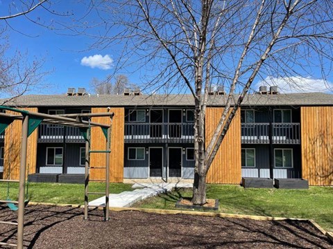 an apartment building with a playground in front of it