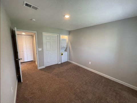 an empty room with a washer and dryer in a closet