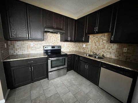 a kitchen with stainless steel appliances and black cabinets