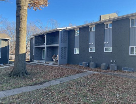 an apartment building with a tree in front of it