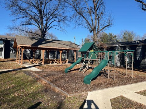 a playground with slides and a pavilion in a park