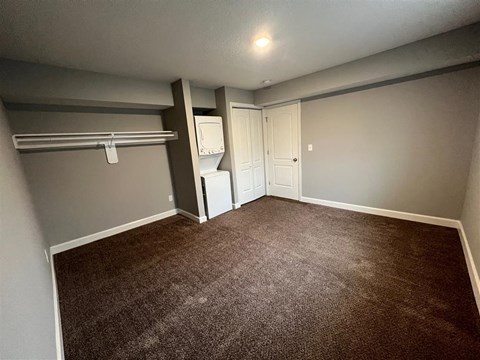 a bedroom with an open closet and washer and dryer