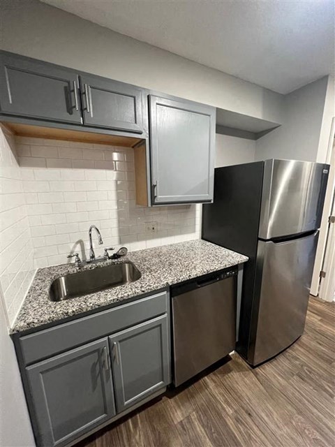a kitchen with a sink and a stainless steel refrigerator