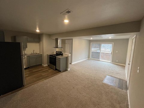 an empty room with a kitchen and a living room