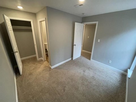 a bedroom with a carpeted floor and a closet