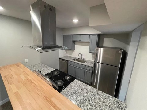 a kitchen with a stove and a stainless steel refrigerator