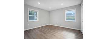 A room with light grey walls and a wooden floor.
