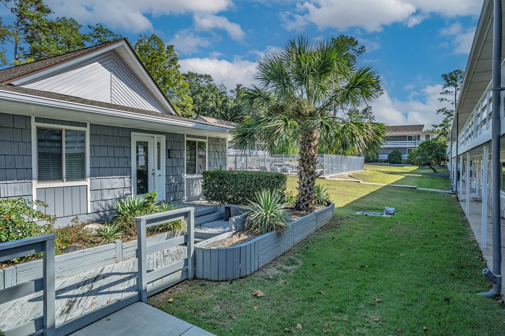 A house with a white fence and a green lawn.