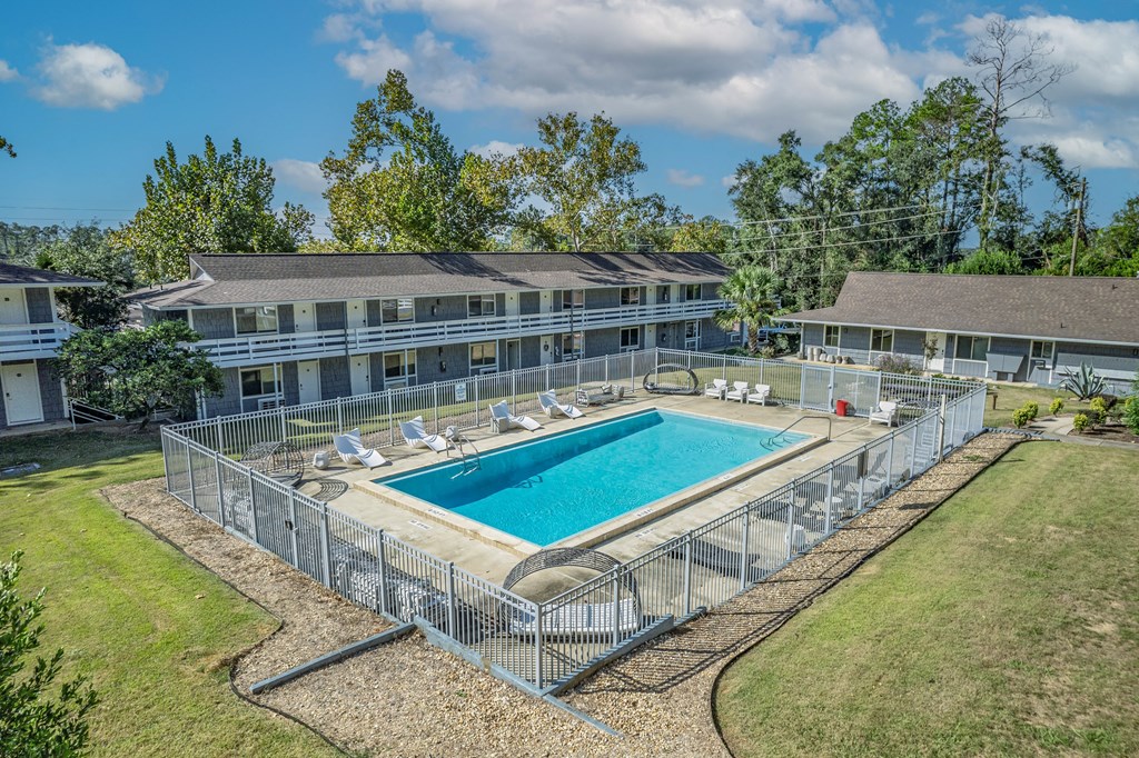 A large outdoor pool surrounded by a metal fence.