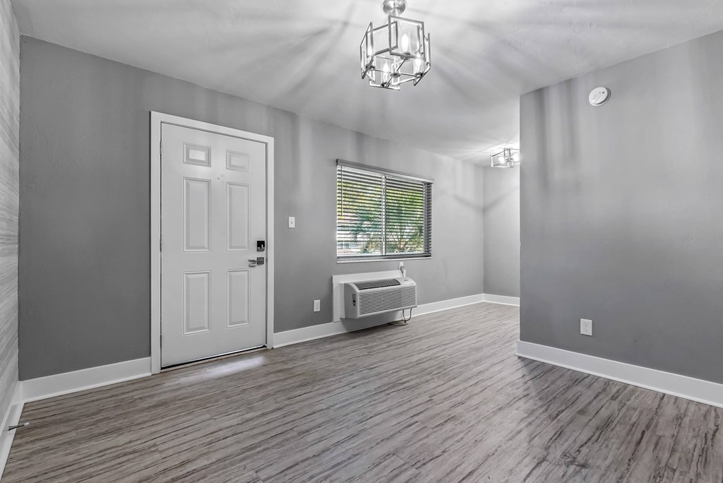 A room with a white door and a window with blinds.