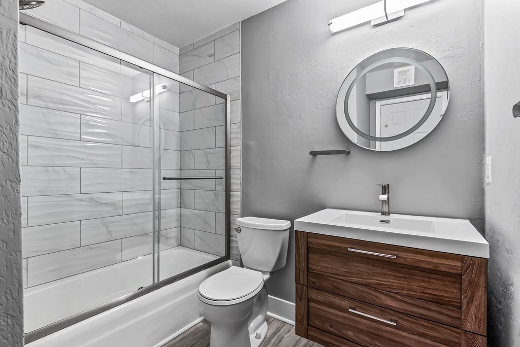 A bathroom with a toilet, sink, and shower.