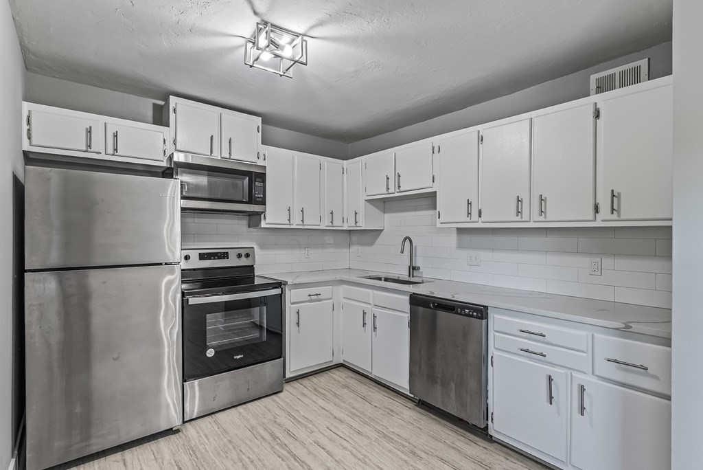 A kitchen with white cabinets and stainless steel appliances.