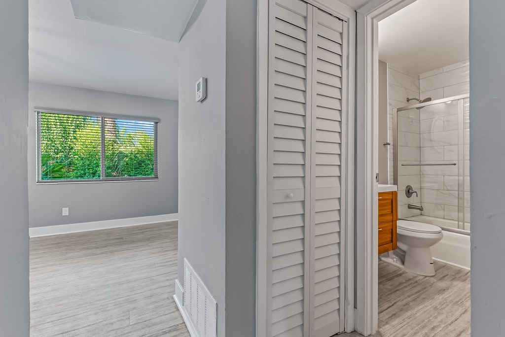 A bathroom with a toilet and a window with a view of trees.