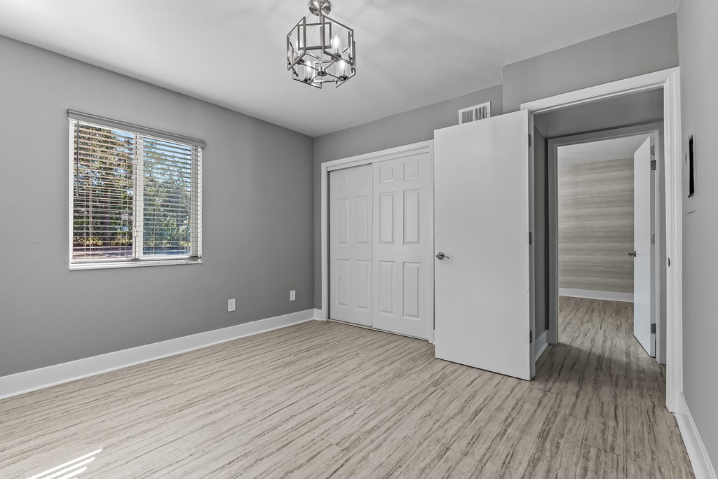 A room with a white door and a chandelier hanging from the ceiling.