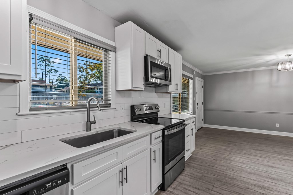 A kitchen with white cabinets and a black stove top oven.