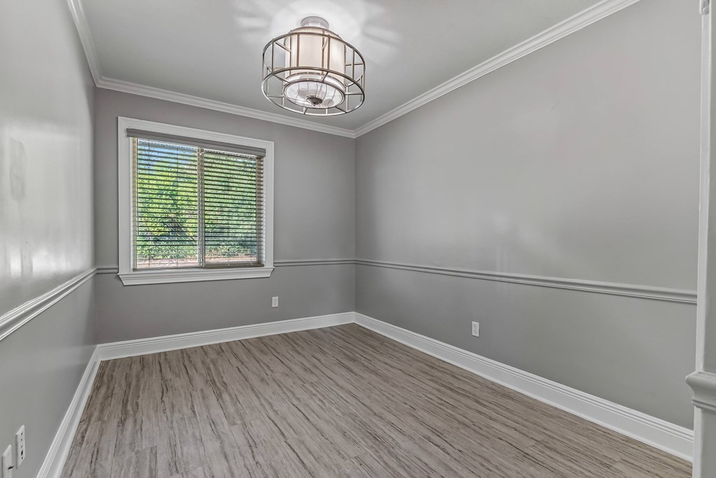 A room with a window and wooden flooring.