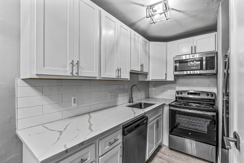 A kitchen with white cabinets and stainless steel appliances.