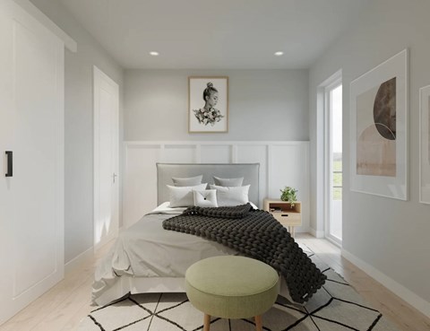 A modern bedroom with a large bed and a green ottoman.