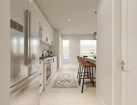 A modern kitchen with stainless steel appliances and a dining area with a table and chairs.