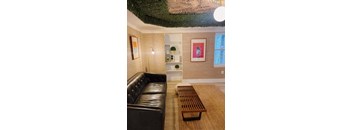A living room with a black leather couch and a wooden coffee table.