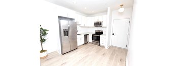 A kitchen with a refrigerator, oven, microwave, and cabinets.