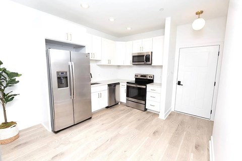 A kitchen with a refrigerator, oven, microwave, and cabinets.