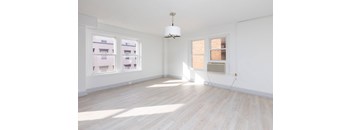 A room with wooden flooring and a chandelier hanging from the ceiling.